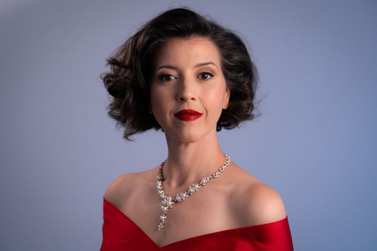Lisette Oropesa in a red off-shoulder gown and pearl necklace, photo by Steven Harris